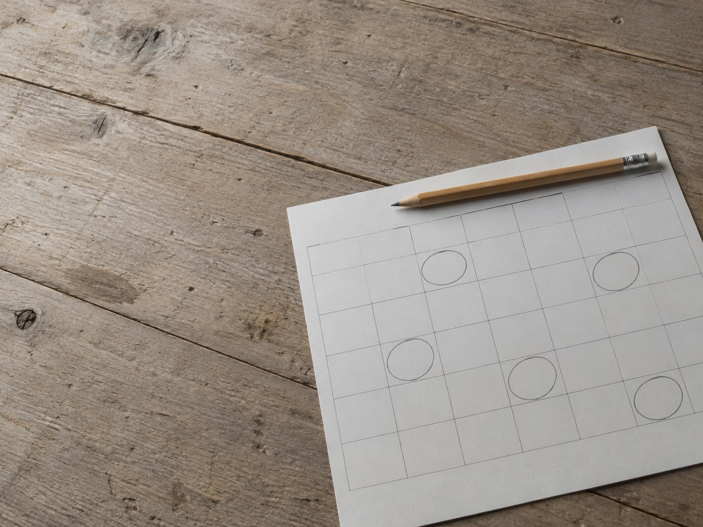 A paper calendar page with several days circled in pencil, a pen resting across the top.