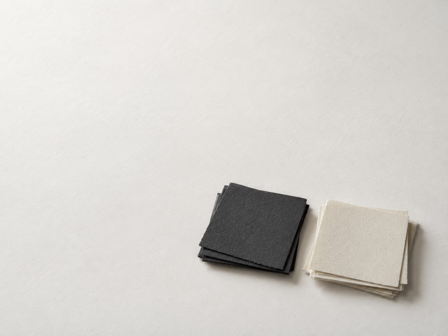 Dark and pale paper color swatches stacked next to each other on a plain white surface.