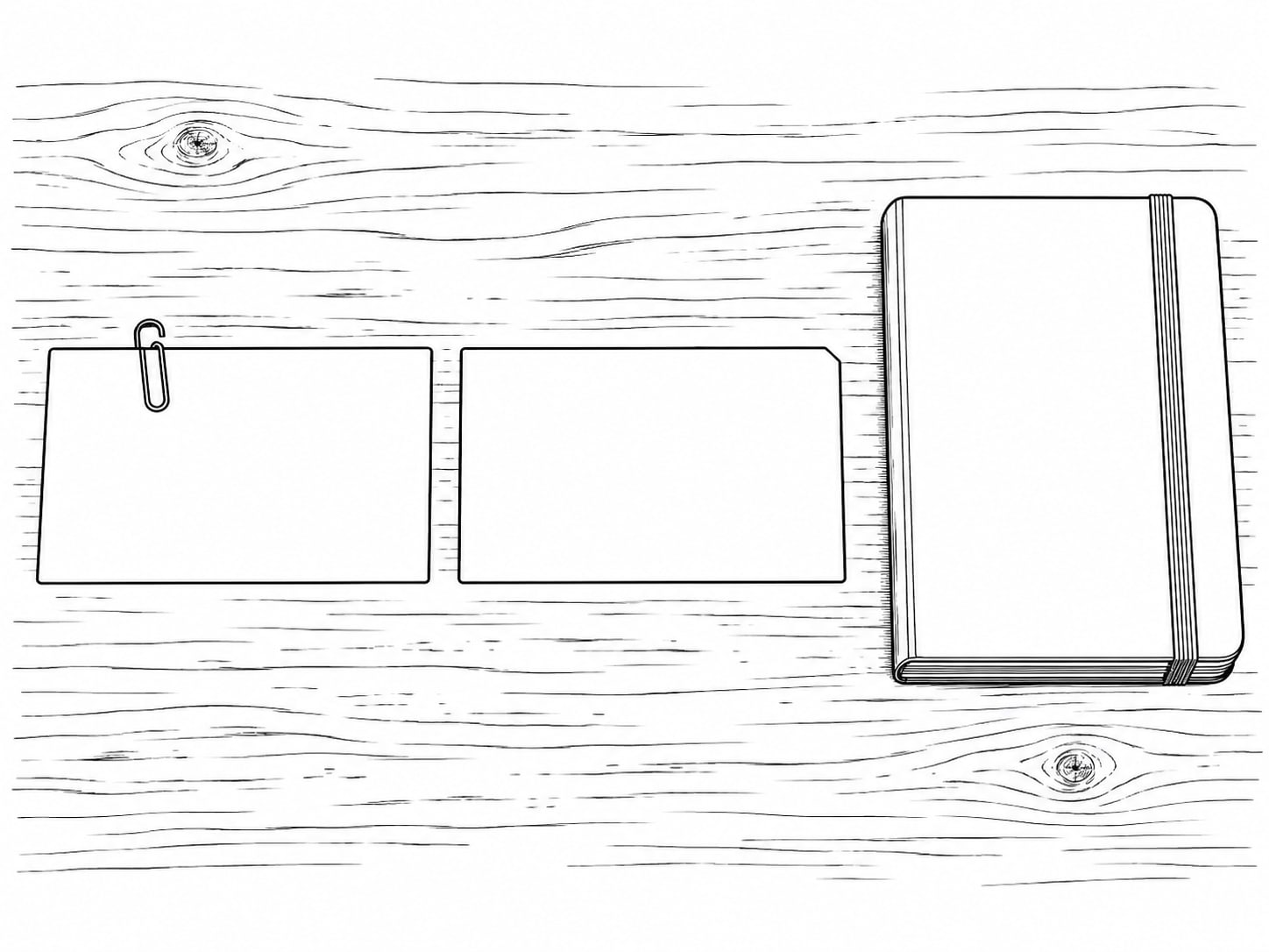 Dos tarjetas en blanco casi idénticas, una al lado de la otra sobre un escritorio de madera gastada, una con un clip, junto a una libreta cerrada.
