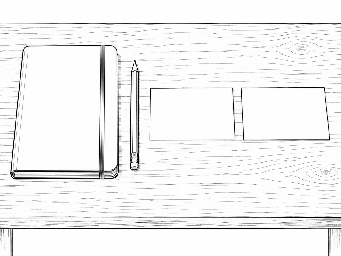 A plain notebook, a pencil and two blank index cards laid side by side on a wooden desk, one card slightly apart from the other.
