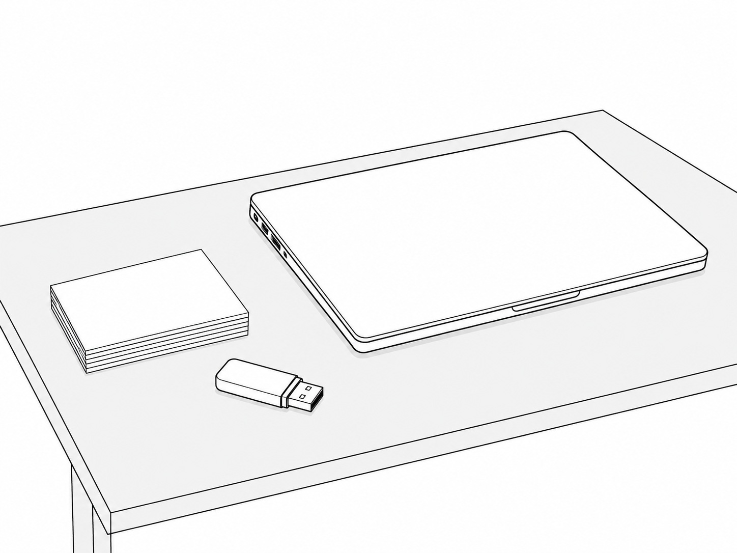 A small unlabeled USB drive beside a stack of blank white cards and a closed laptop on a gray desk.