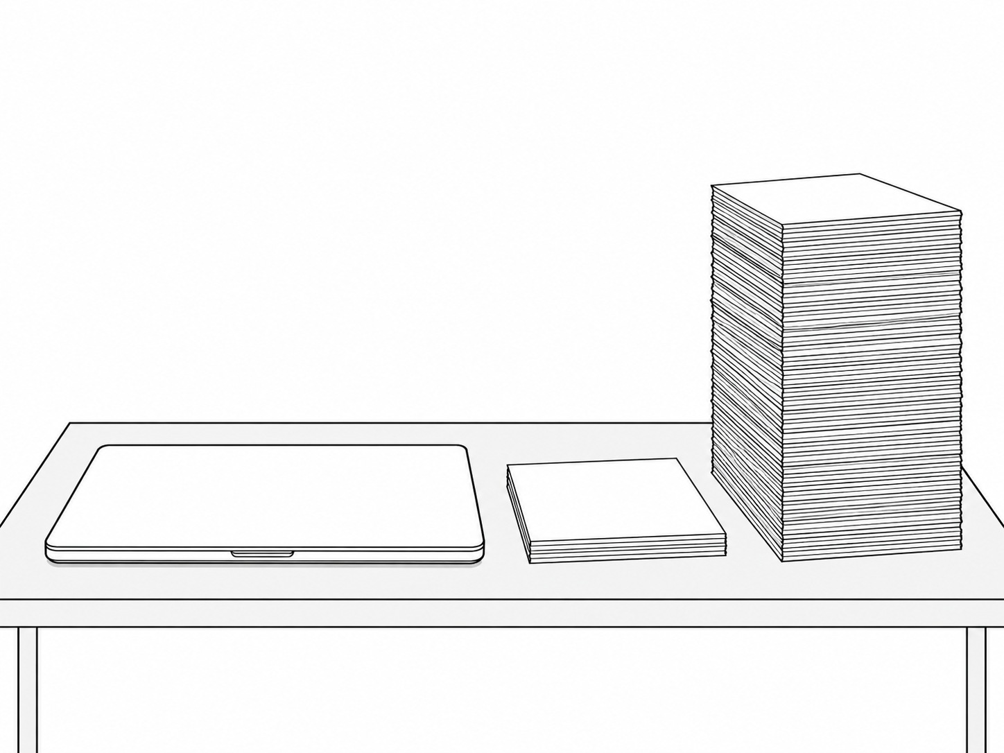 A closed laptop beside two stacks of blank paper of very different heights on a pale wooden desk.