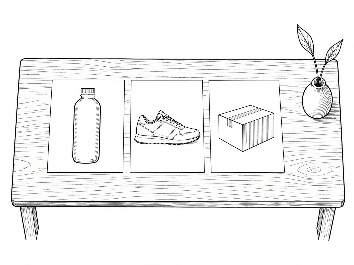 Three printed product photographs laid side by side on a light oak table next to a small ceramic vase.