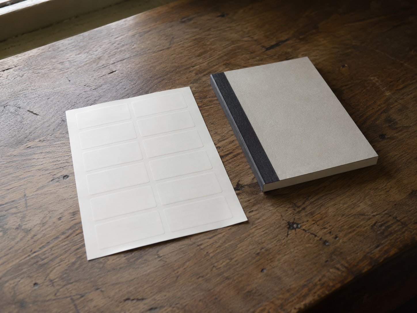 A blank sticker sheet beside a closed receipt book on a shop counter.