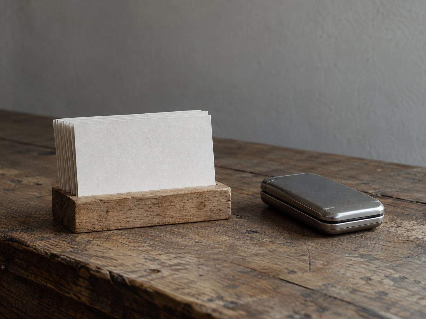 A row of blank appointment cards standing in a wooden holder beside a closed phone.