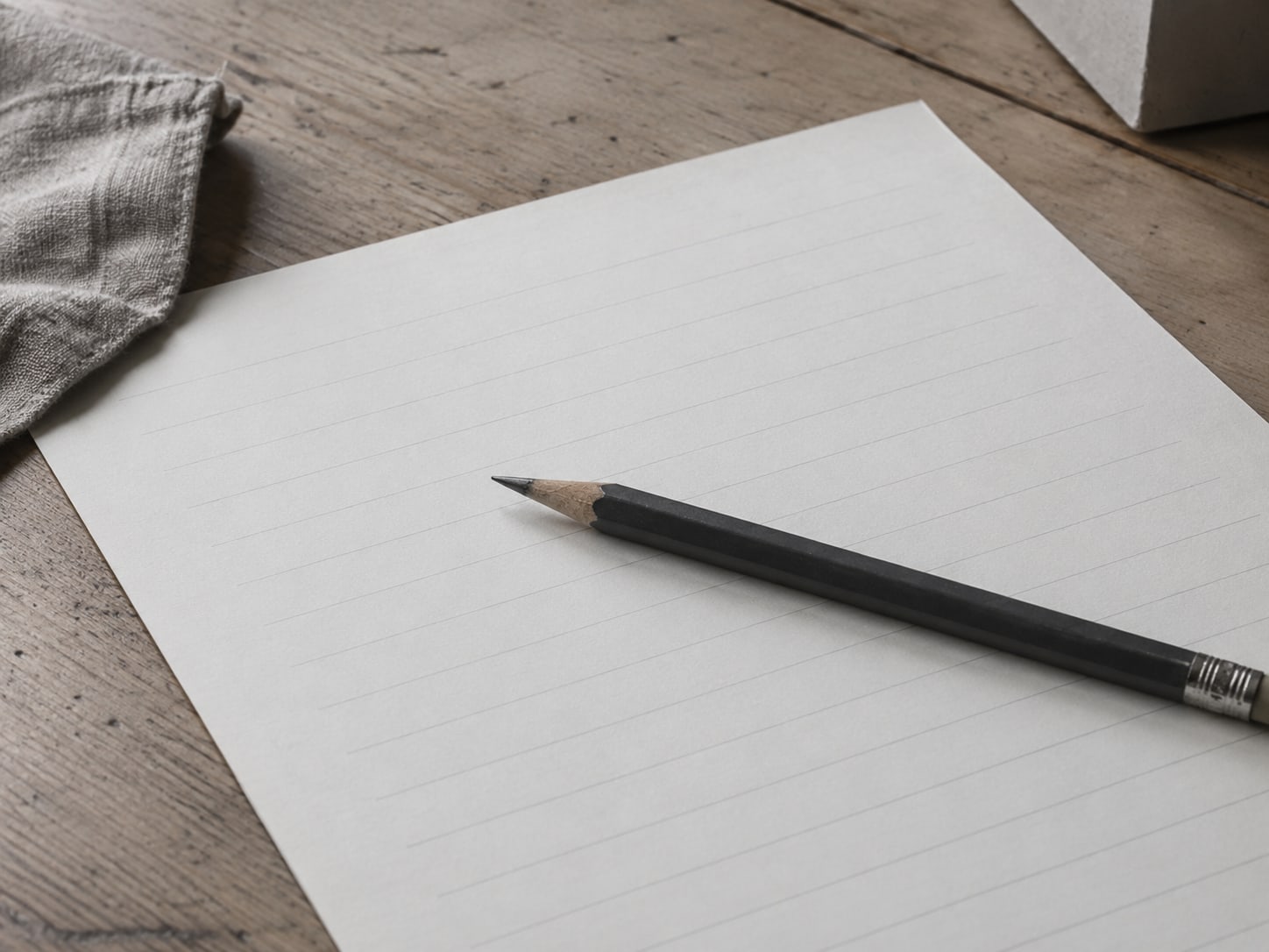 A pencil lying across a printed blank form with empty lines on a clean desk.