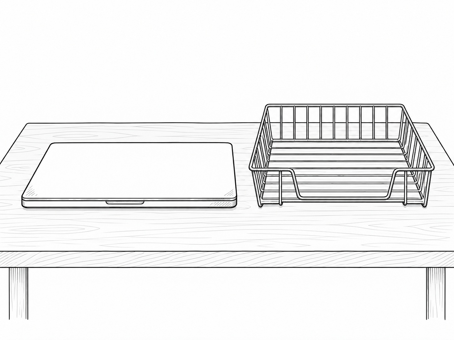 An empty wire letter tray beside a closed laptop on a pale oak desk.