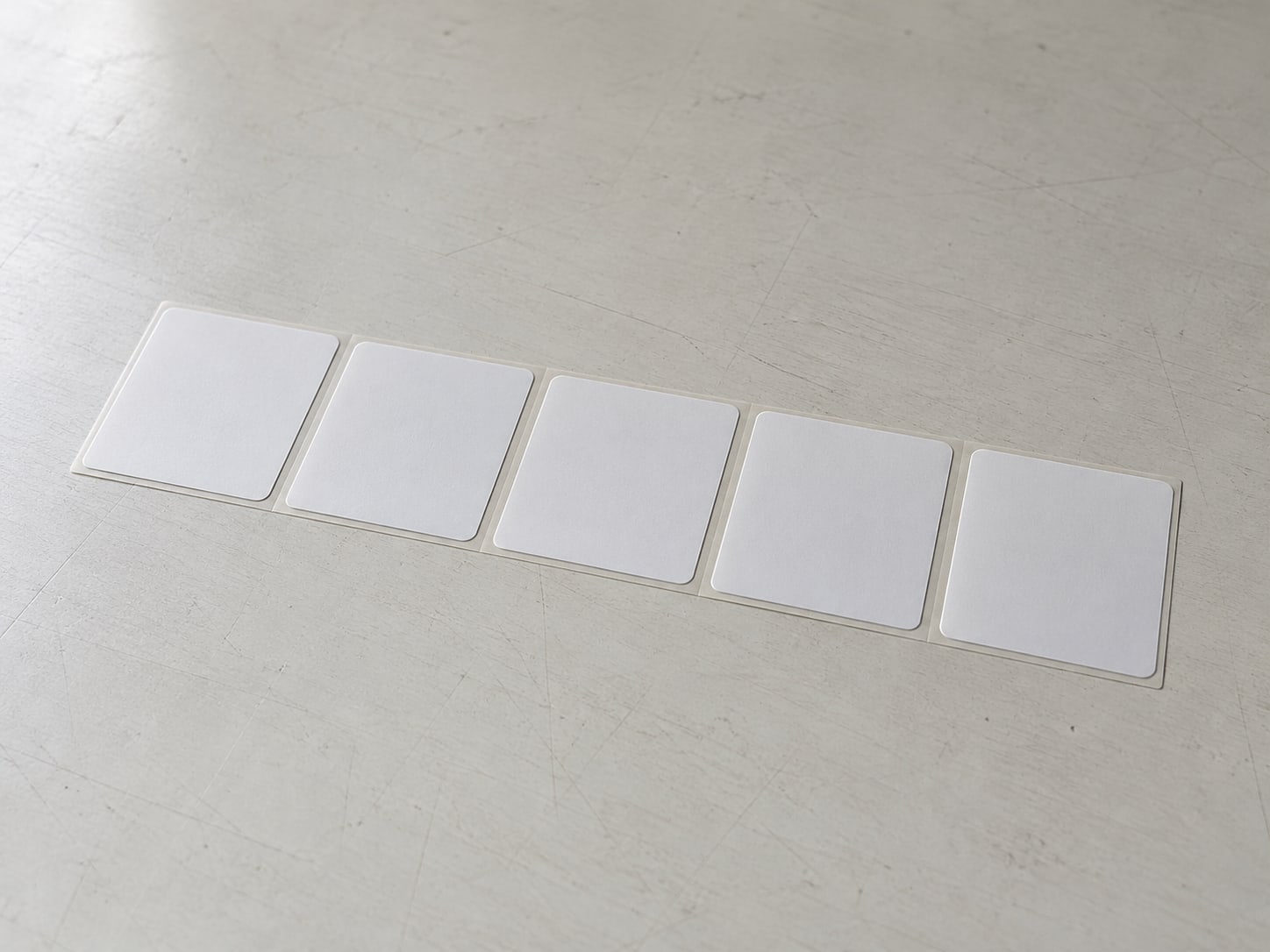 A neat row of identical blank shipping labels on a clean worktable.